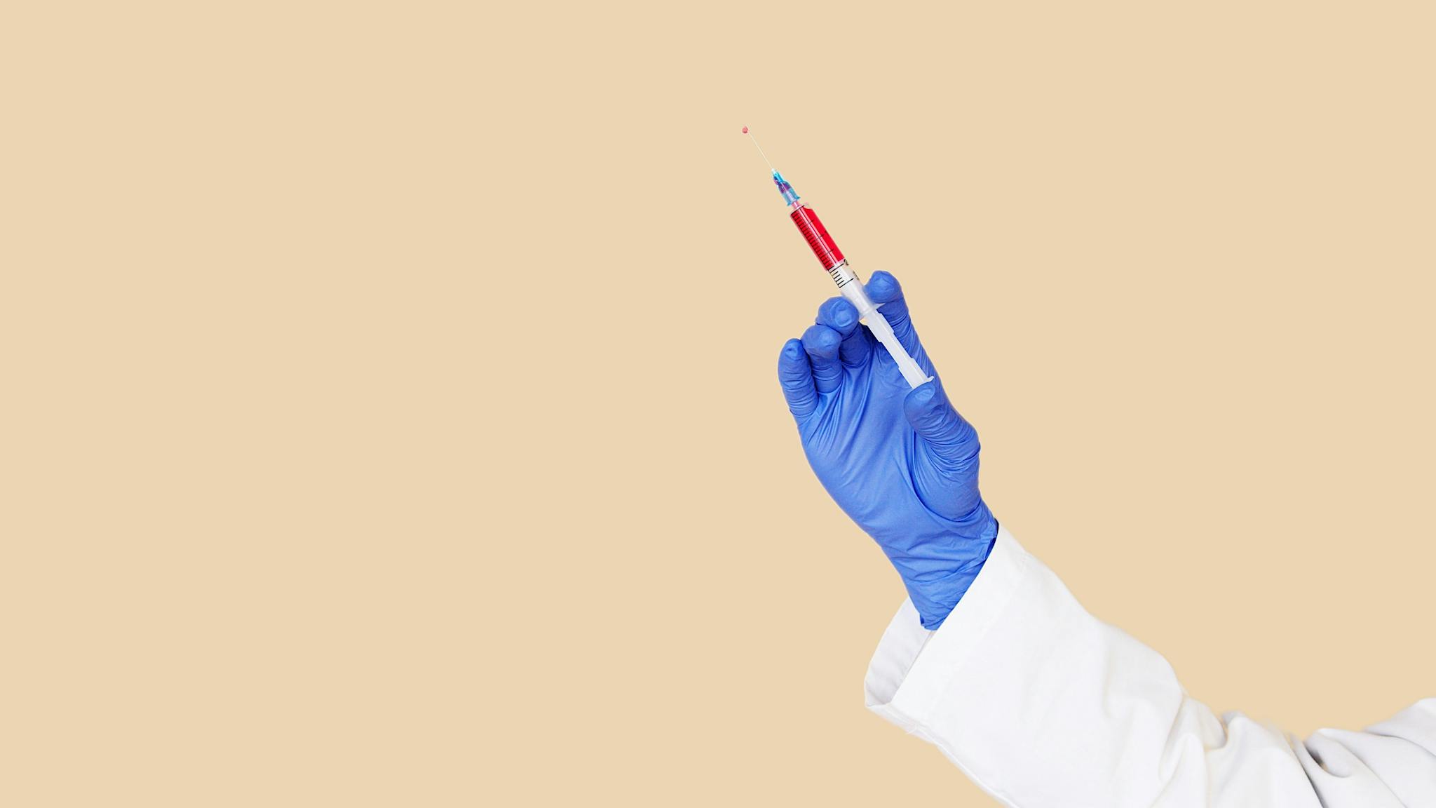Crop doctor in white uniform and blue gloves with syringe